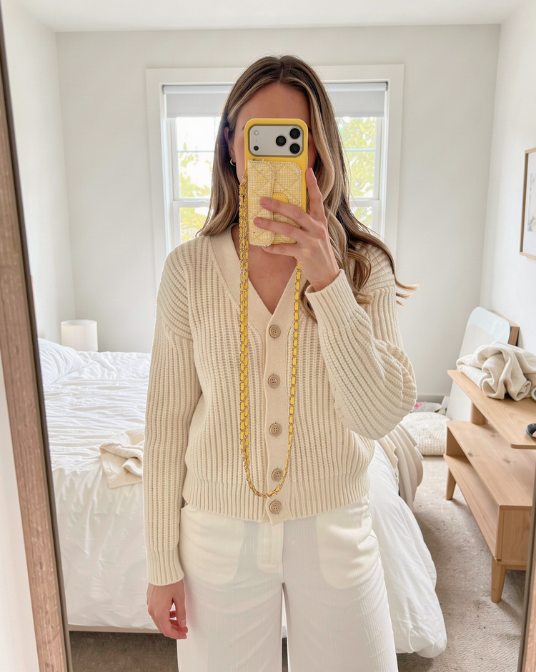 Lemon tweed phone case worn with a cream cardigan
