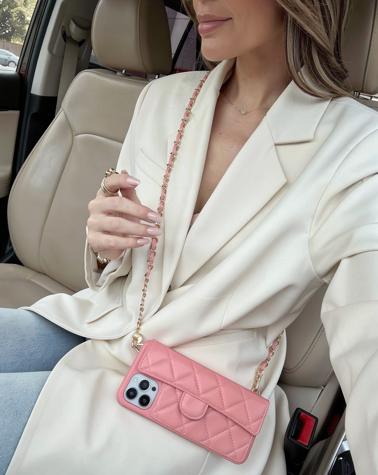 Powder pink quilted phone case worn crossbody with a cream blazer